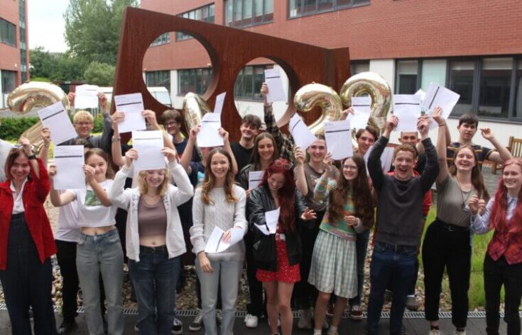 Group of students holding pass certificates and cheering