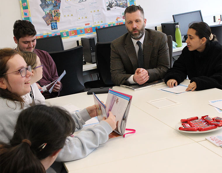 Photograph of a group of students completing a reading challenge with a teacher.