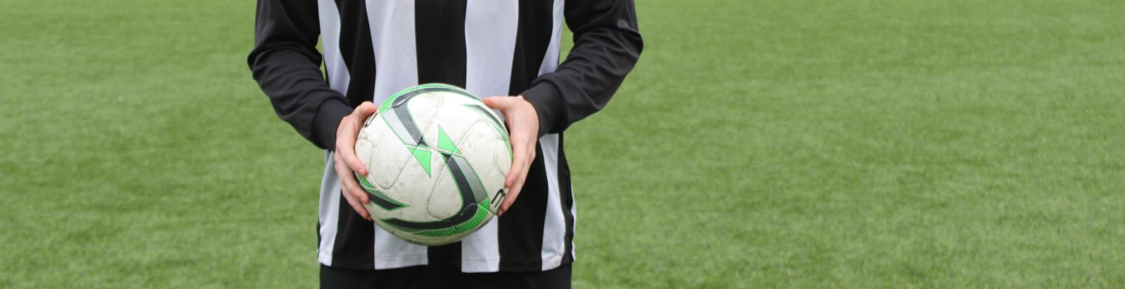 Student holding a football for a photograph.