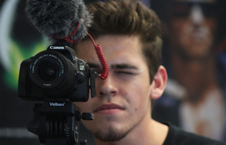 Photograph of a student looking through a camera.