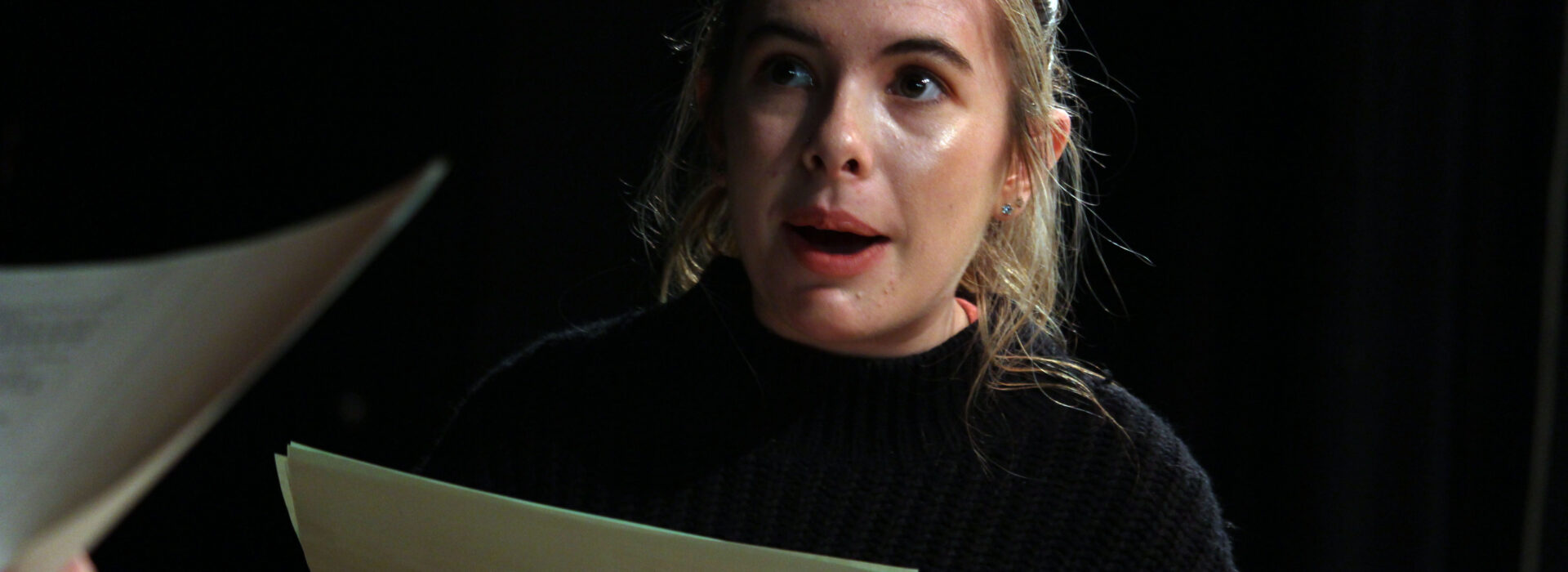 Photograph of a drama student reading a script