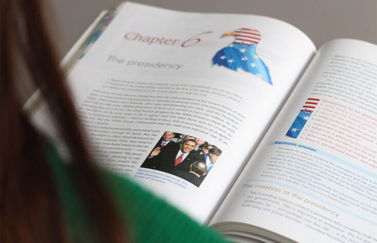 Photograph of a student reading a politics book.